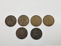 Lot of six antique UK bronze pennies laid out in two rows, some with patina and wear visible.