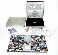 Overview photo of lot showing the two Official Millennium Keepsake tin cases open with coins and souvenir stamps, and the Canada 150 booklet with stamps spread out