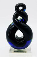 Front angle of black and deep blue twisted art glass sculpture on clear crystal base with Murphy's label.