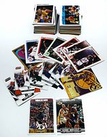 Large lot of NBA trading cards spread out showing individual cards featuring Magic Johnson, Kobe Bryant, and others in varied designs and years.