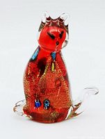 Front view of the red and gold fleck art glass cat figurine showing clear glass ears, tail and multicolored flecks