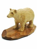 Front-right angled view of handcrafted wooden bear sculpture showing carved fur texture and facial details on a wooden base.