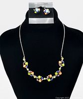 Front view of necklace and earrings on display stand, showing colorful glass bead clusters and sterling silver chain.