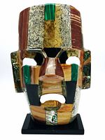 Front view of a vintage Mexican mosaic death mask with colorful semi-precious stones including abalone, onyx, and malachite.