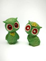 Photo of both green owl salt and pepper shakers, showing detailed facial features and flower accents.