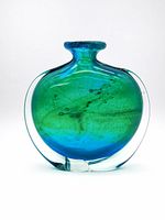 Front view of vase showing flattened disc shape and blue-green interior stripes within clear casing