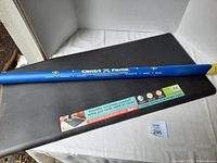 Blue Centri Force exercise bar laid horizontally on black Comfort Mat with product label visible.