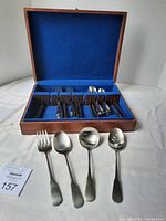 Full flatware set in wooden felt-lined case, utensils sorted in compartments