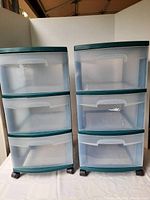 Front view of two identical Sterilite storage drawer units standing side by side, showing translucent drawers and green trim.