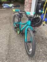 Front angled view of teal Specialized Rip Rock 24-inch girls bike with black saddle, tires, and yellow-accented chain guard.