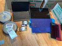 Overview of lot items including Microsoft Surface with keyboard, Amazon Kindle, blank CDs and USB adapters/cable accessories