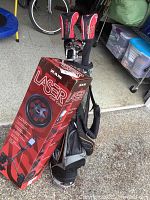 Boxed RAM Laser golf cart leaning against stand bag