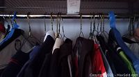 Assorted shirts hanging on rack, full lot overview