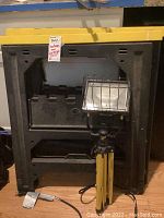 Two Stanley folding plastic sawhorses stacked together with halogen work light in front.