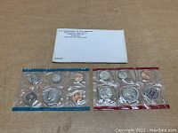 Two sealed 1972 US proof coin sets with half dollar, quarter, dime, nickel, and penny coins, along with original Department of Treasury envelope.