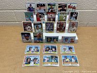 Front view of vintage baseball card collection displayed in two clear stands and laid on a table surface, showing player photos and team names.