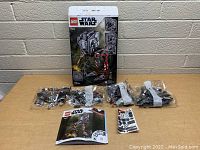 Photo showing the unopened LEGO bags numbered 1 and 3, instruction manual, and sticker sheet laid out in front of the box.