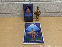 Photo showing the Josiah figurine placed on table with original box behind and story booklet in front.