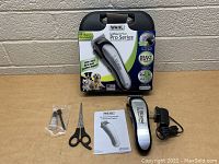 Kit layout showing Wahl Lithium Ion Pro Series pet clipper, box, charger, scissors, blade guard, and manual on tabletop.