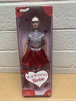 Front view of Barbie doll inside original box with heart-shaped label and pink/red design