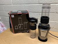 Photo of the Yabano smoothie maker, drinking cup, and original product box on a table.