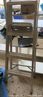 Photo of aluminum 4-foot step ladder in folded position indoors.