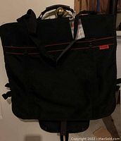 Black Patrol travel tote bag with handles and shoulder strap, red Patrol logo tag visible