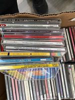 Overhead photo of CDs arranged vertically in a box showing individual spine titles such as John McCormack and Arturo Rubinstein.