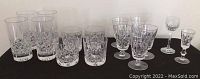 Full view of all crystal drinkware, showing group of tumblers, highball glasses, footed glasses, and two liqueur glasses varying sizes and shapes