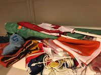 Multiple flags folded alongside a green bag on a shelf