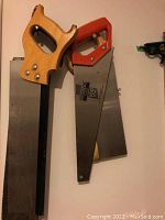 Three hand saws with metal blades and wooden and plastic handles arranged vertically showing blade teeth and handles
