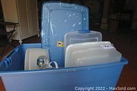 Blue plastic storage tote with several assorted translucent plastic food containers with lids inside.