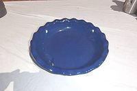 Top view of the deep dish pie plate showing blue glazed interior and scalloped edges.