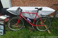 Full side profile of the red Norco street mountain bike with 26-inch wheels, rear rack, and water bottle on frame.