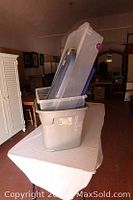 Clear and gray plastic storage totes stacked, one clear tote with a lid on top.
