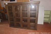 Front view of the solid wood shelving cabinet with glass-paneled doors