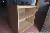 Front view of wood veneer end table showing two shelves and light wood grain finish.