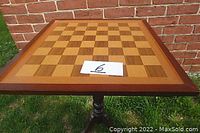 Top view of wooden chess/checkers game table with inlaid board pattern surface