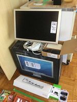 Apple 20-inch Cinema Display with cables, Apple wired keyboard, router box and dock box beneath