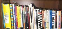 Shelf of assorted books about art, graphic design, typography, and illustration, showing titles like FontBook, Design Identity, and others.