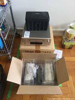 Photo of Teac R-H500 cassette deck on its original box and a wrapped Bose speaker in open box packaging.