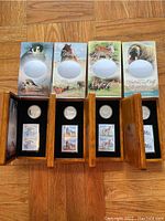 All four wooden cases with original illustrated sleeves displayed open on floor.