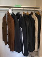 Side view of the nine jackets hanging next to each other on hangers. Various colors like brown, black, and beige visible.