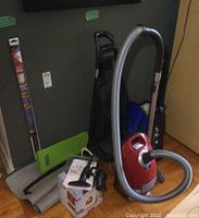 Overall layout showing vacuum, hose, shopping cart, mats and bags