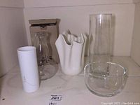 Front view of all vases and decanter arranged on shelf showing size and style variety.