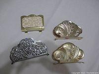 Four assorted napkin holders displayed together to show size and design differences