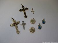 Photo of assorted religious pendants showing crosses and medallions with various materials and designs.