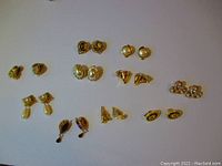 Full set of twelve pairs of vintage gold-tone clip-on earrings with various designs including faux pearls, floral patterns, and geometric shapes.