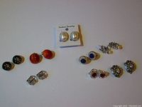 All four pairs of vintage clip-on earrings arranged in a row on white background.