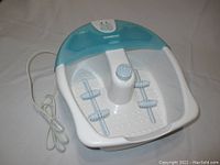 Full view of the Conair Vibrating Health Foot Spa unit showing the white basin with blue splash guard and attached power cord.